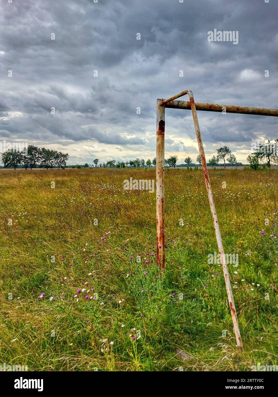 Abandoned soccer field under sky with stormclouds in Germany. Stock Photo