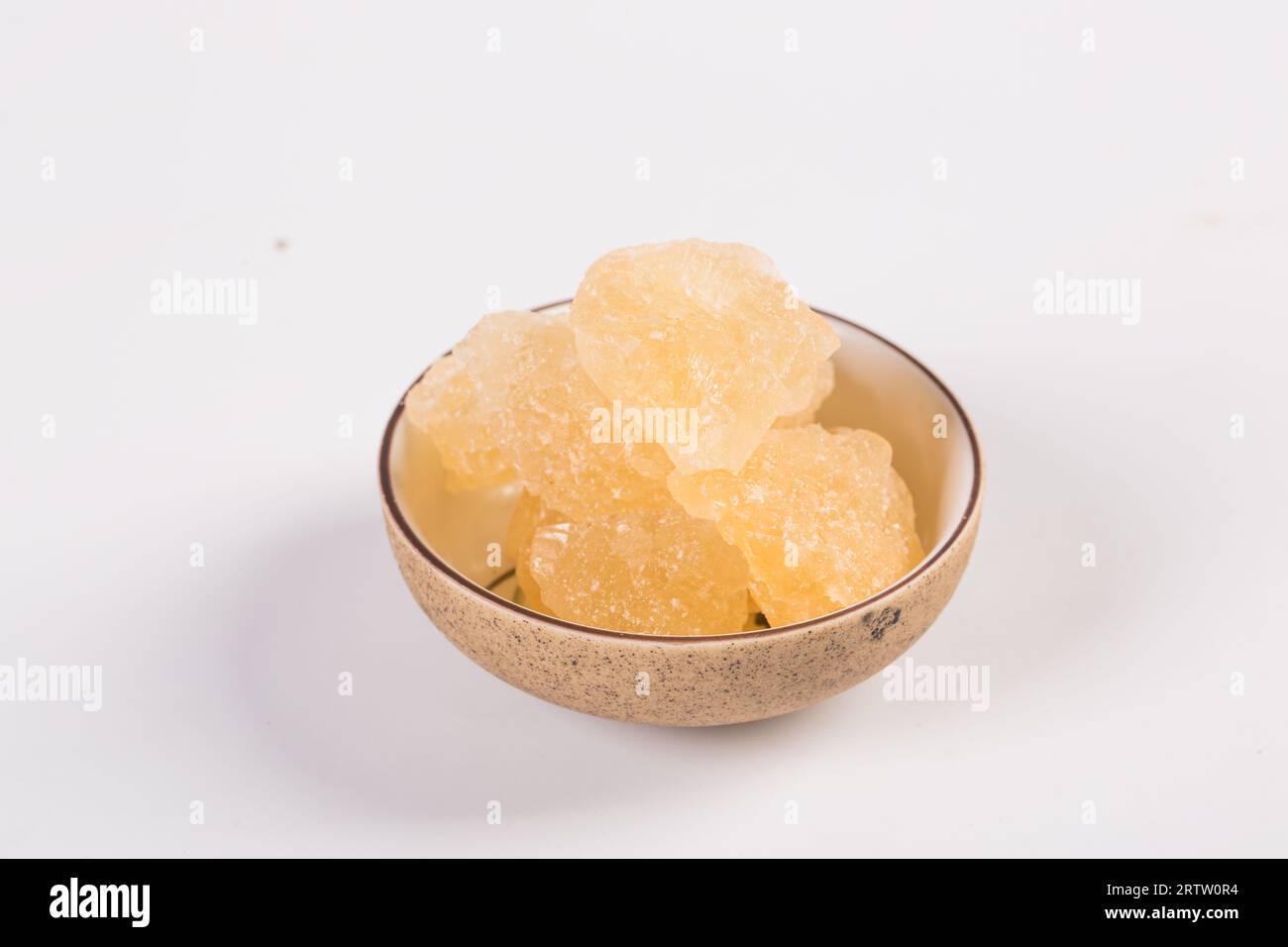 Old Rock sugar in a bowl on white background. Stock Photo