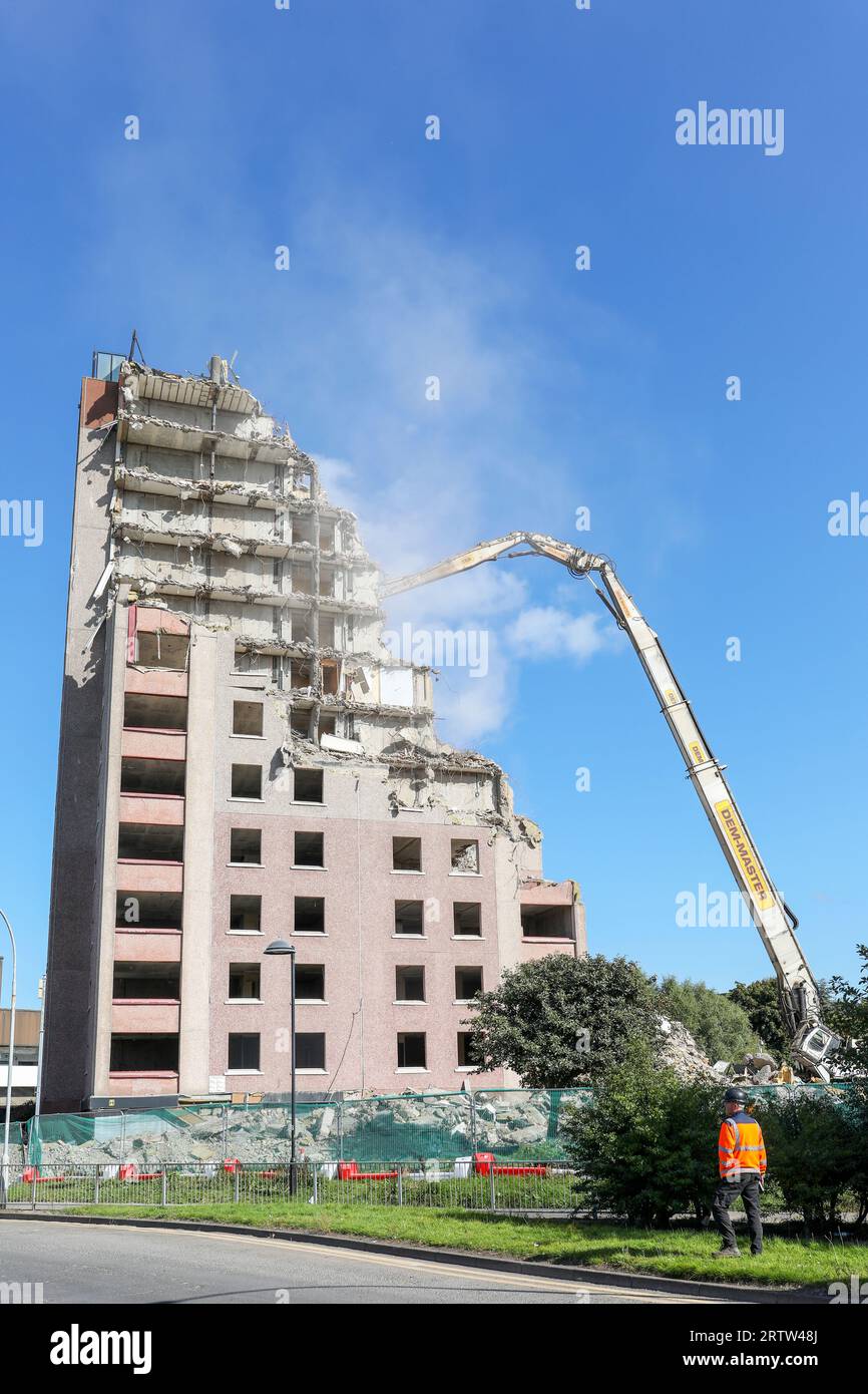 High rise block of flats, Irvine, Ayrshire, Scotland, UK, being demolished by a mechanical crane. Stock Photo