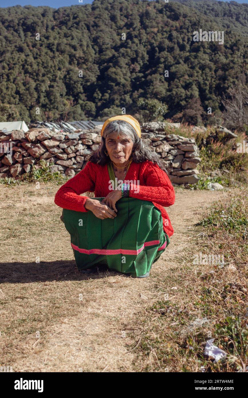 November 30th 2022. Tehri Garhwal, Uttarakhand India. Elderly Garhwali woman in traditional colorful attire posing in Uttarakhand's valleys, India. Stock Photo