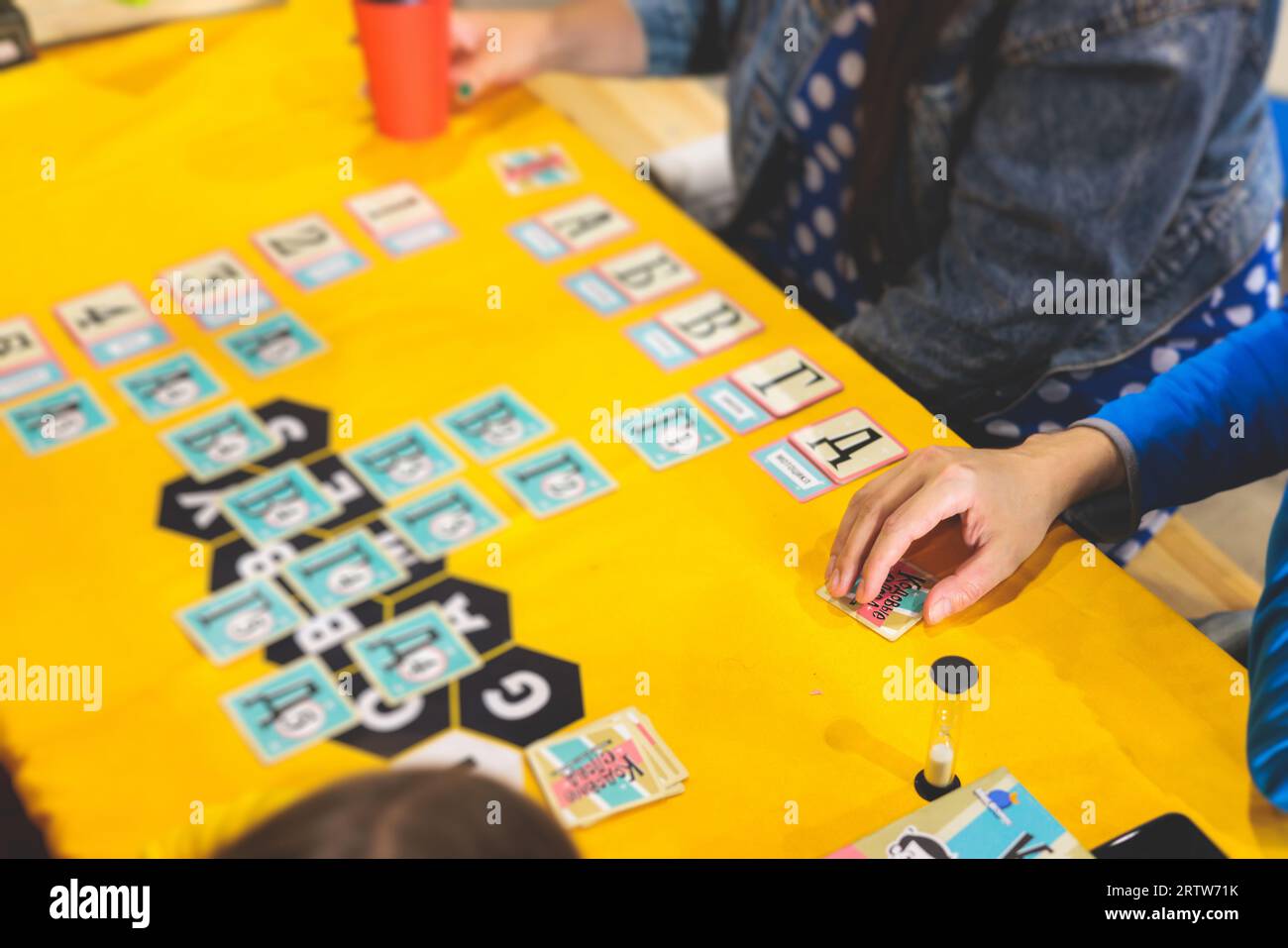 Process of playing board game and having fun with friends and family in room indoors, board game