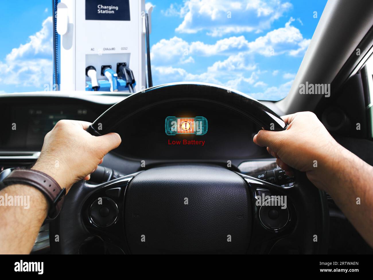 Low battery caution display on screen of a electric car instrument panel, The battery voltage signal is dropping and low, electric car parked on EV ch Stock Photo