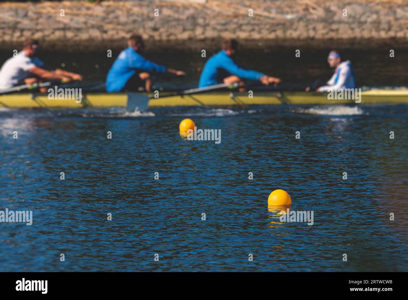 Group of rowing team athletes sculling during competition, kayak boats