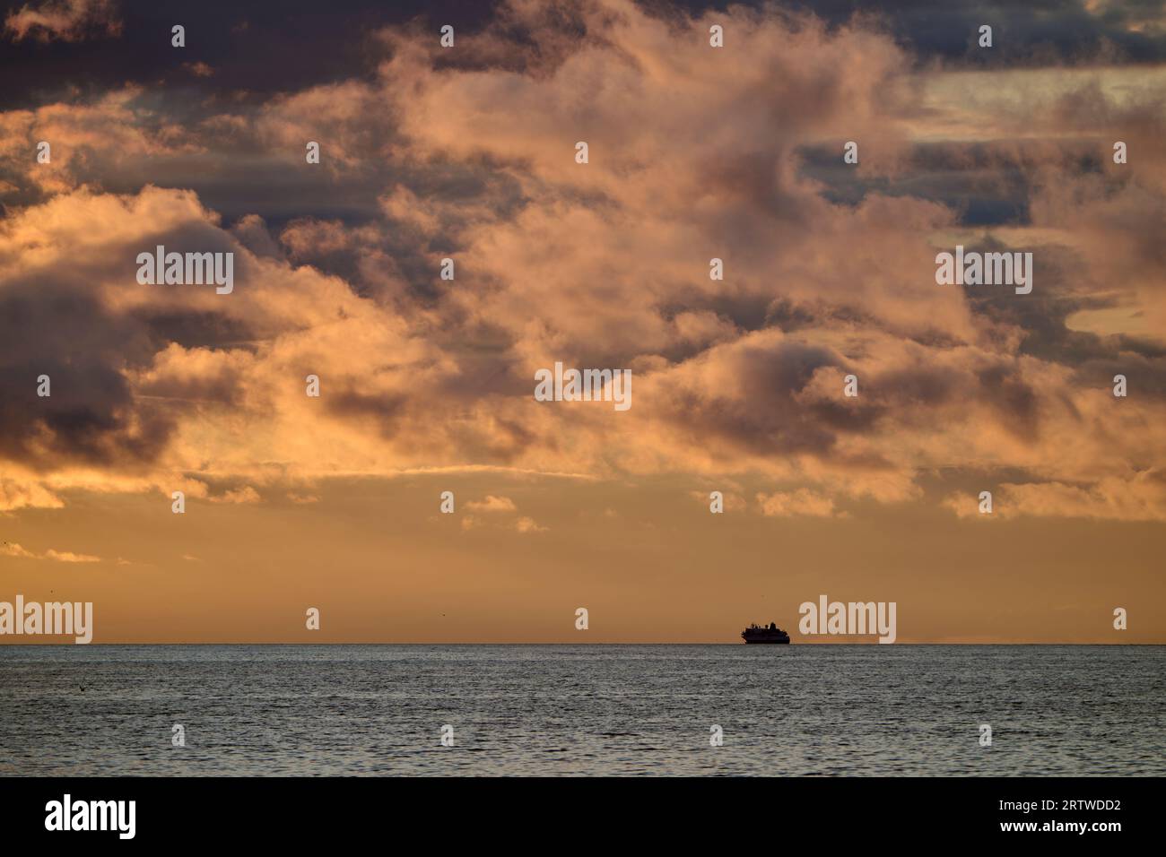 Distant ship sailing in peaceful sunset sea Stock Photo Alamy