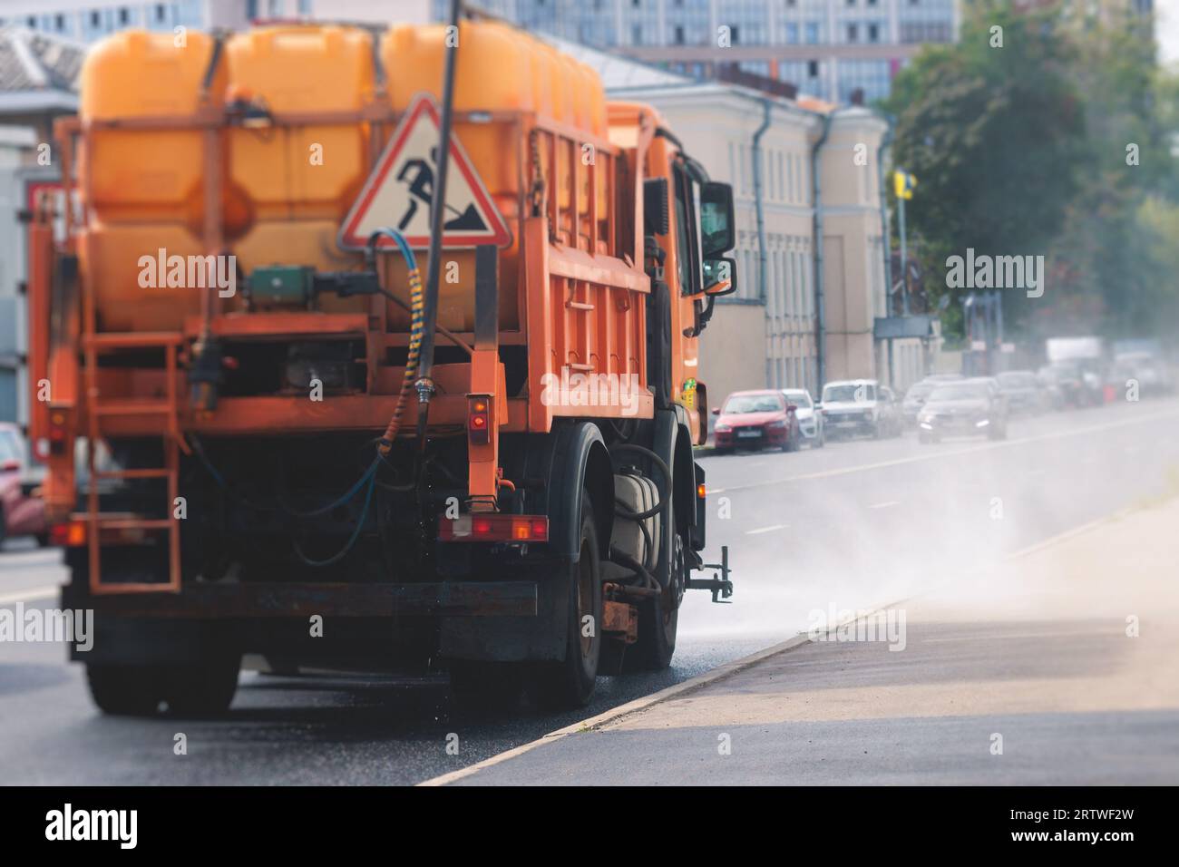Municipal watering truck machines washes asphalt, process of street