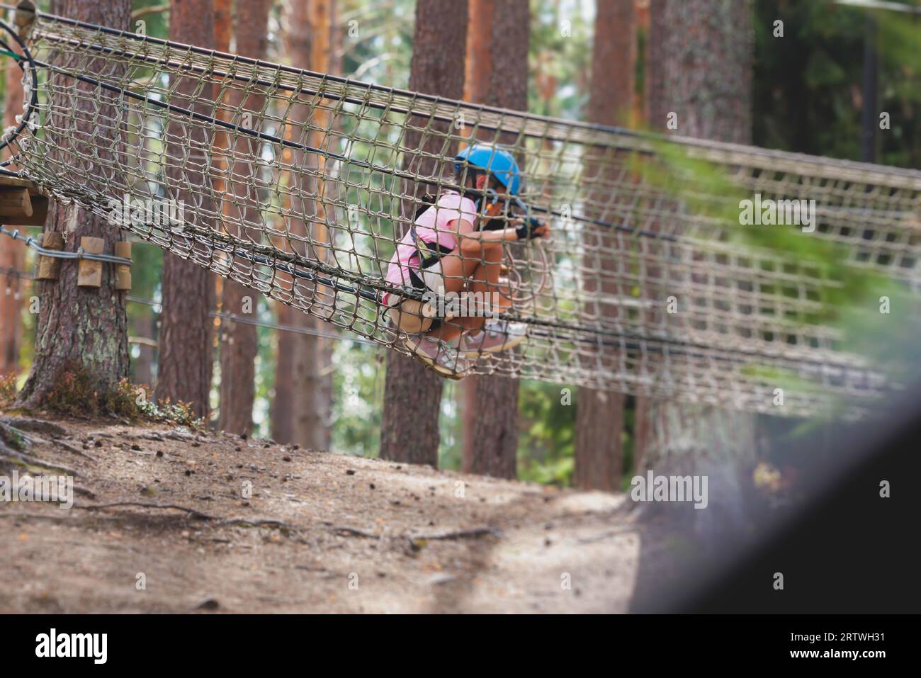 View of high ropes course, kids of climbing in amusement acitivity rope ...
