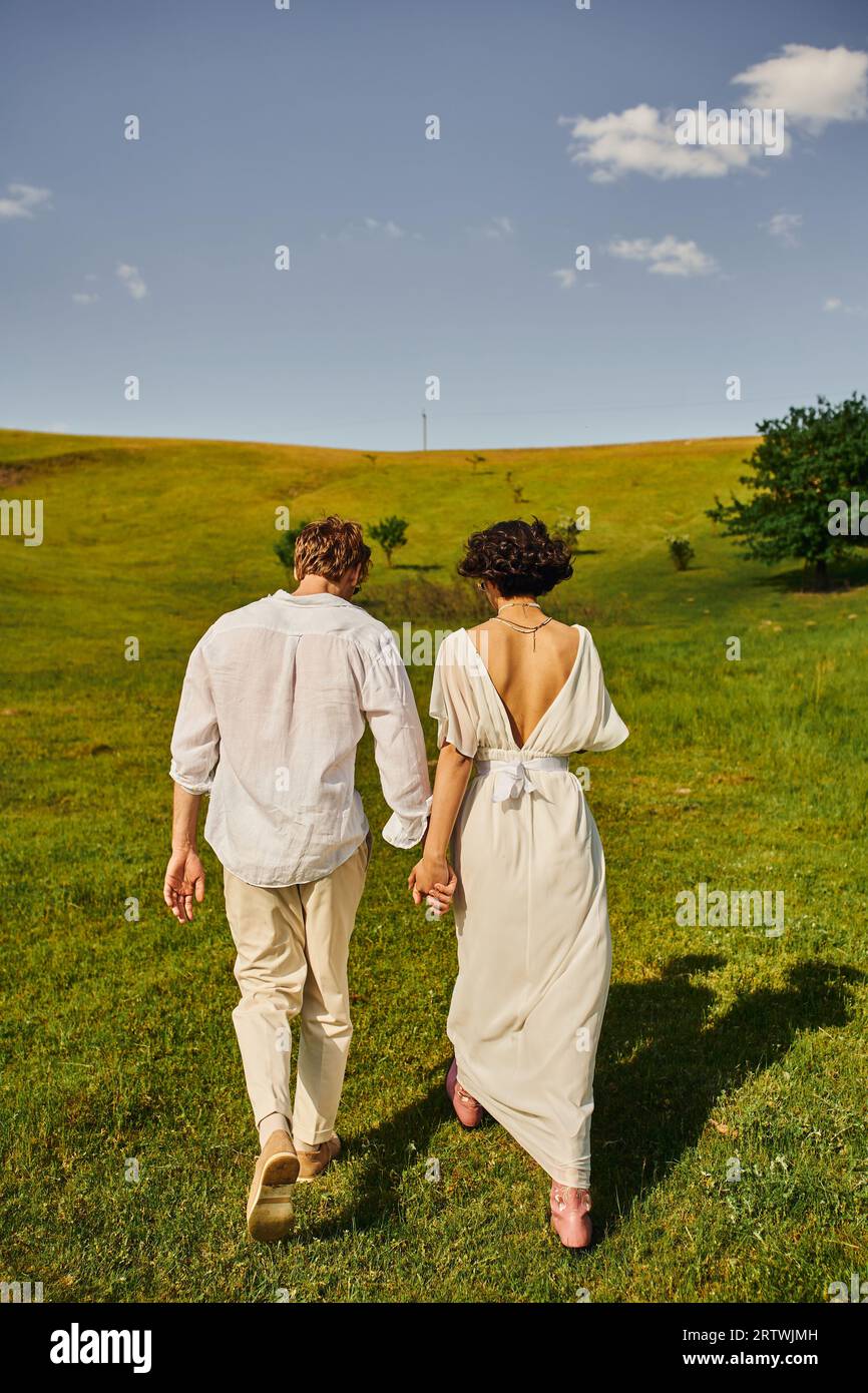 just-married-couple-back-view-of-bride-in-wedding-dress-walking-with