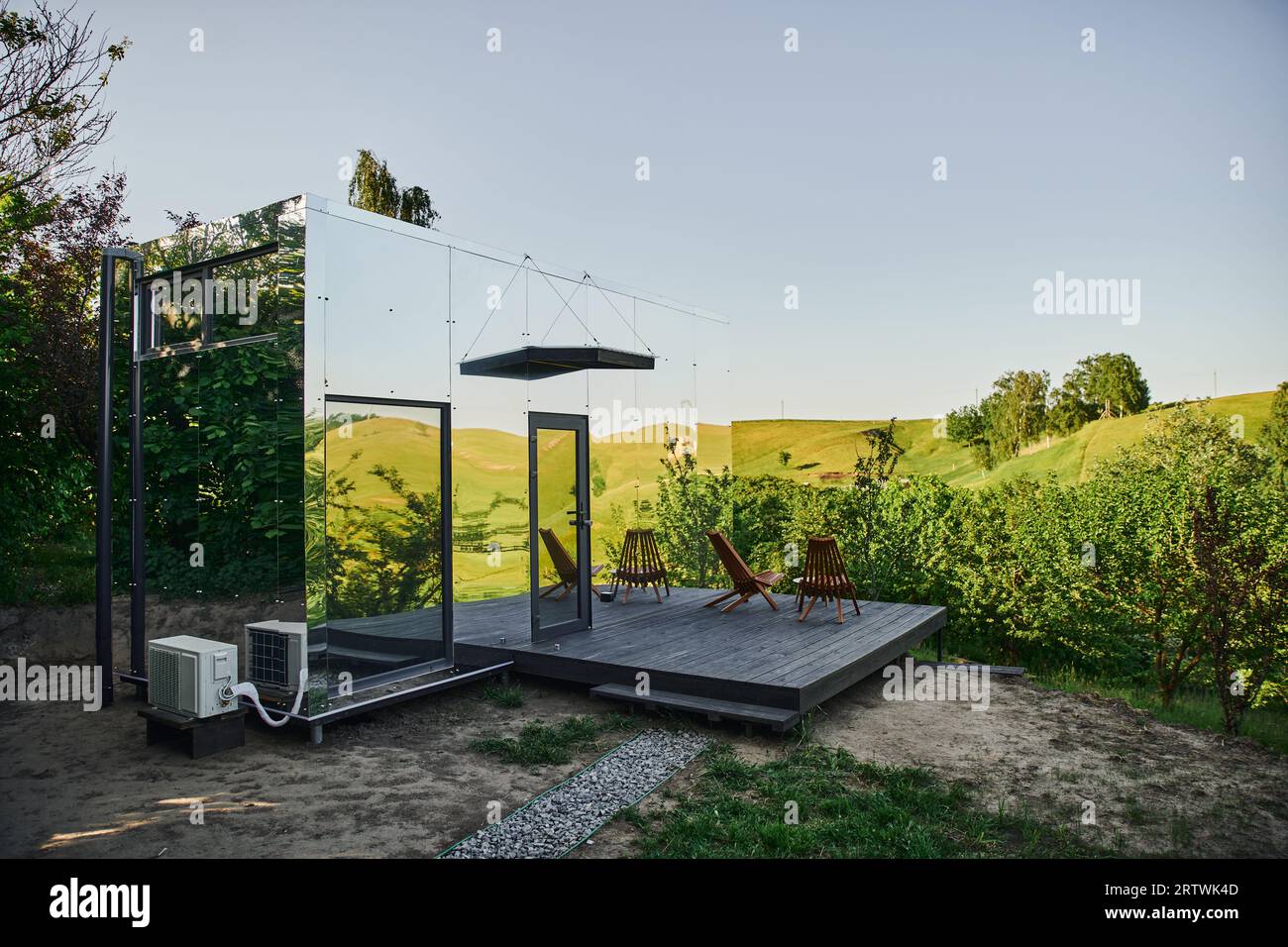 modern minimalistic glass house with chairs and coffee table on porch