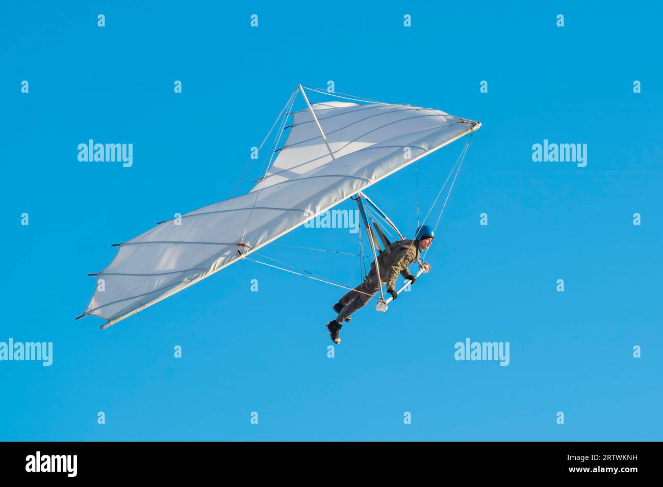 Student learning to fly on white rogallo hang glider wing Stock Photo