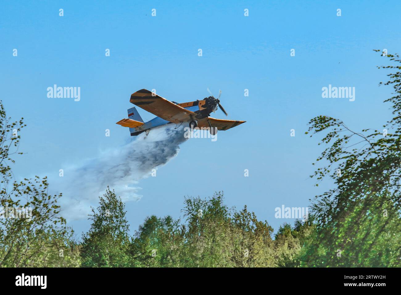 A forest and meadow fire extinguished from the air by a fire-fighting plane Stock Photo