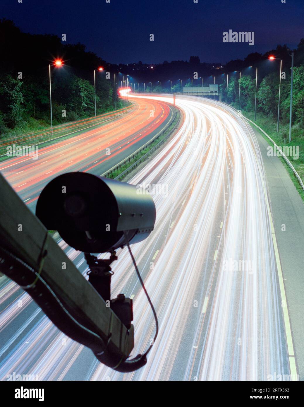 ANPR motorway camera. 'Surveillance state' - camera above lanes of traffic, long exposure at night, UK motorway. Theme, concepts. Copy space. Stock Photo