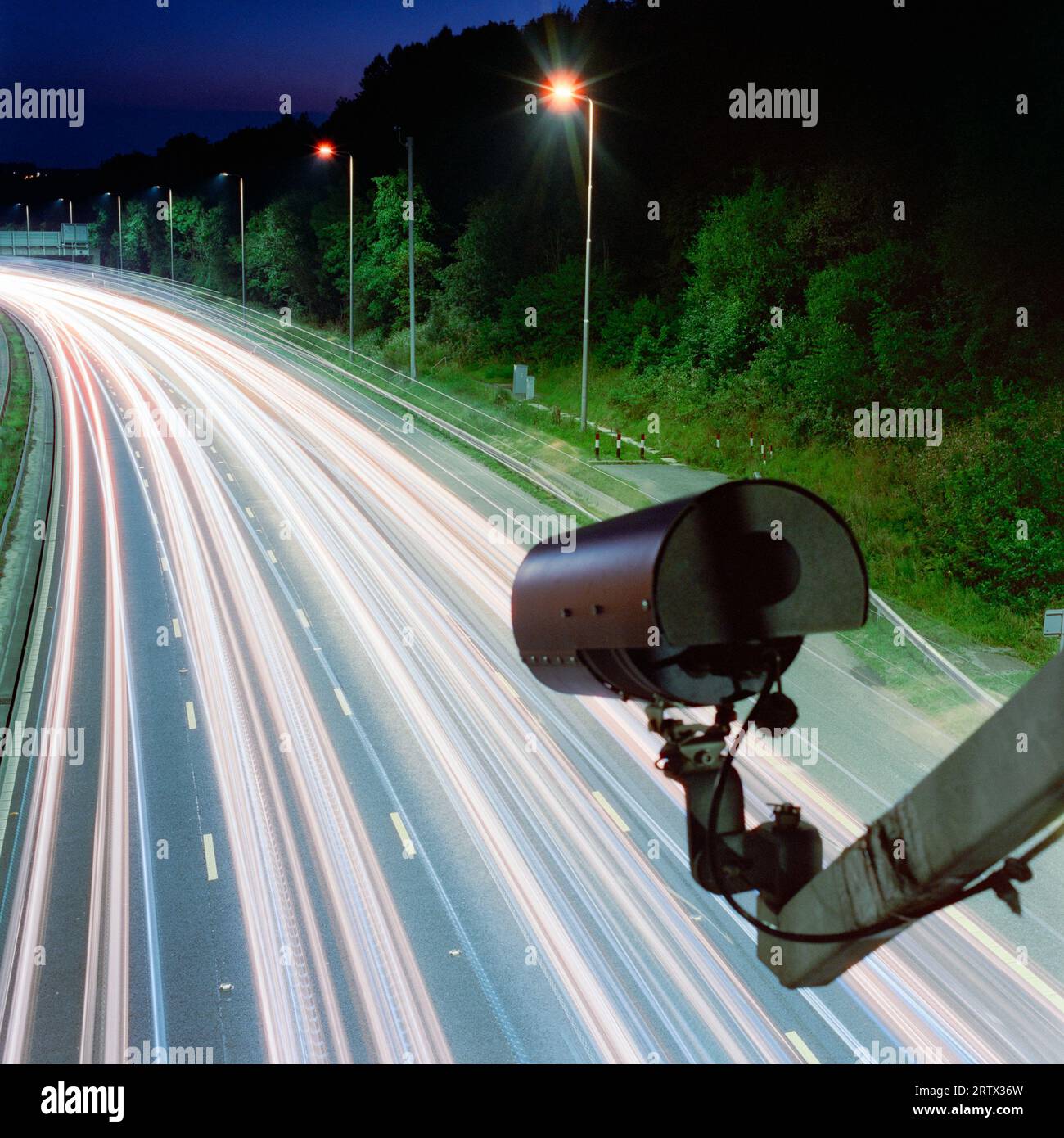 ANPR motorway camera. 'Surveillance state' - camera above lanes of traffic, long exposure at night, UK motorway. Theme, concepts. Copy space Stock Photo