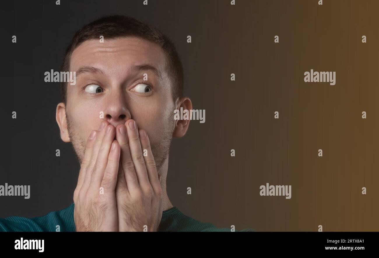 surprised man closing his mouth with his hand Stock Photo