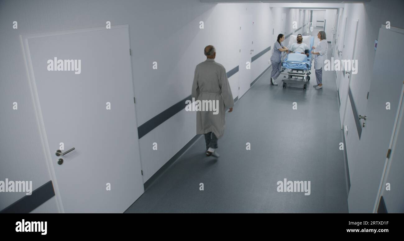 Female doctor and nurse stand in hospital corridor with African