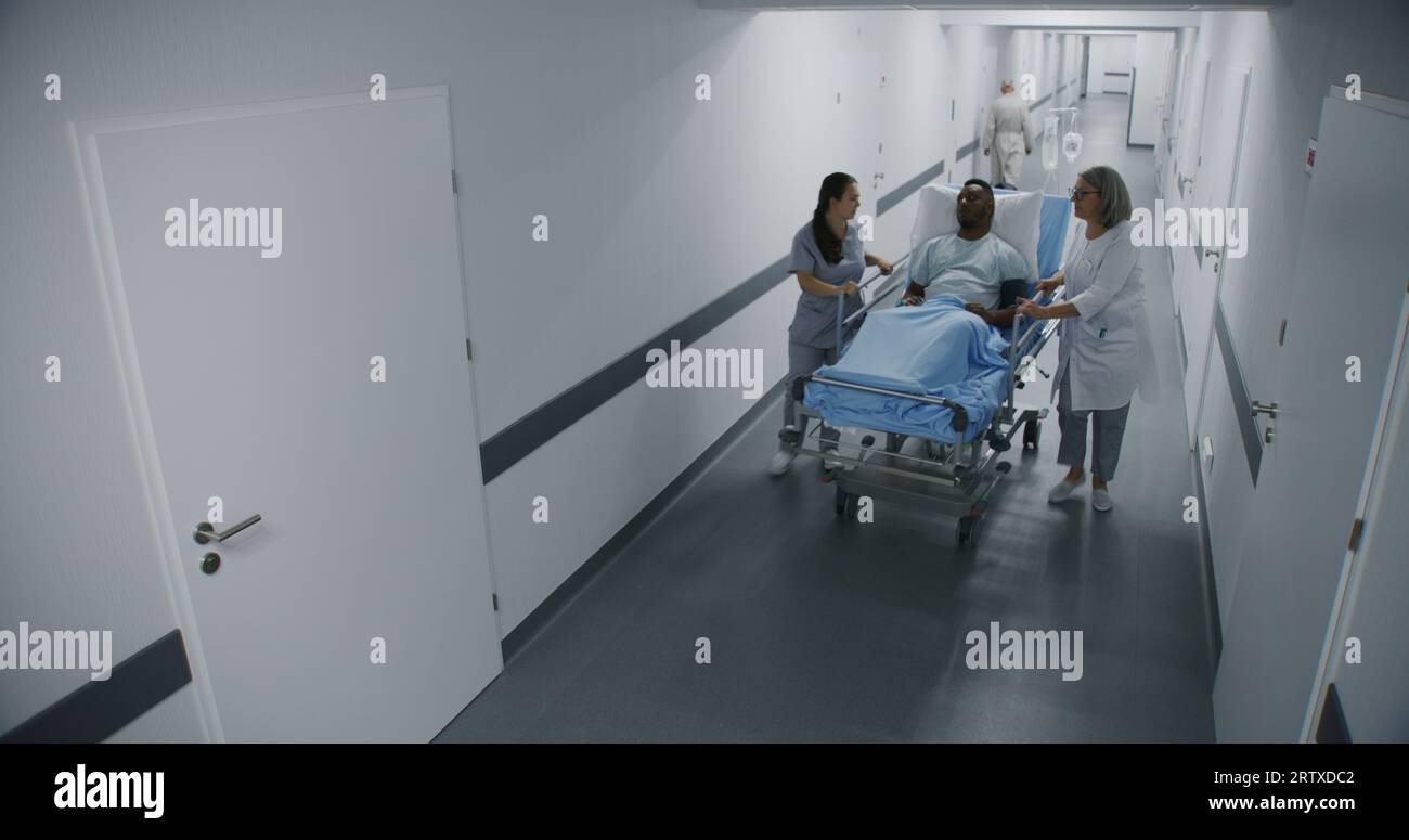Female doctor and nurse stand in hospital corridor with African