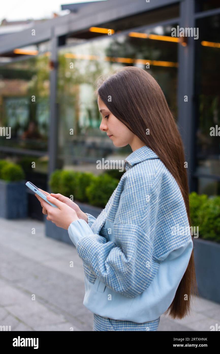 teen girl use smartphone on walking and searching for location on maps, calls a taxi in mobile app Stock Photo
