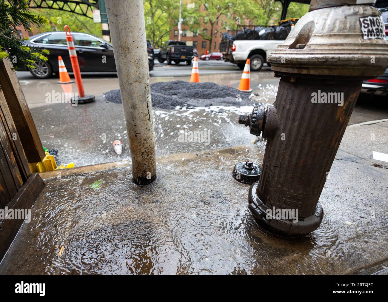 A fire hydrant is leaking on a New York street, 2023 Stock Photo Alamy
