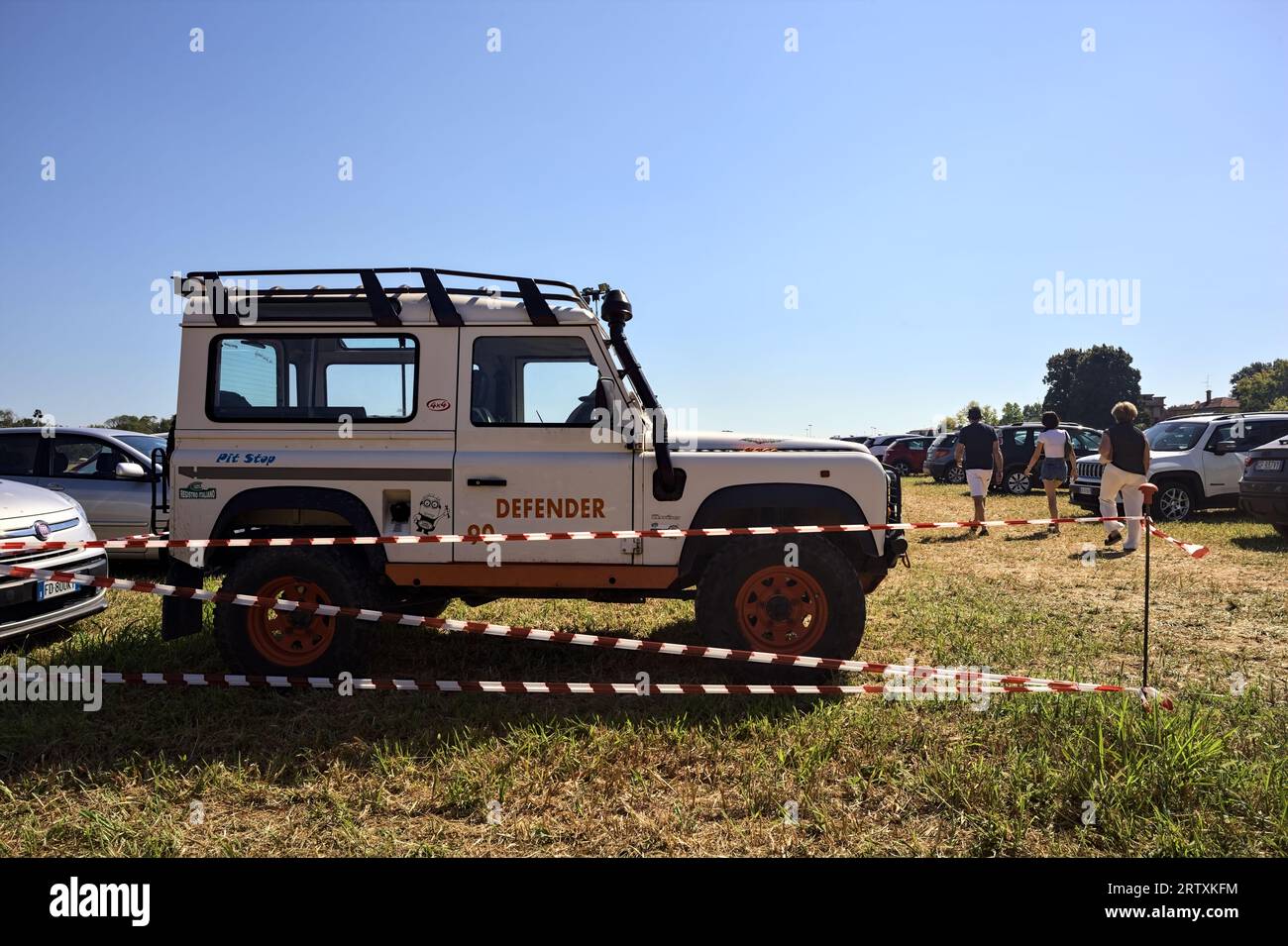 Land  Rover Defender in a parking lot on a mowed field on a sunny day Stock Photo