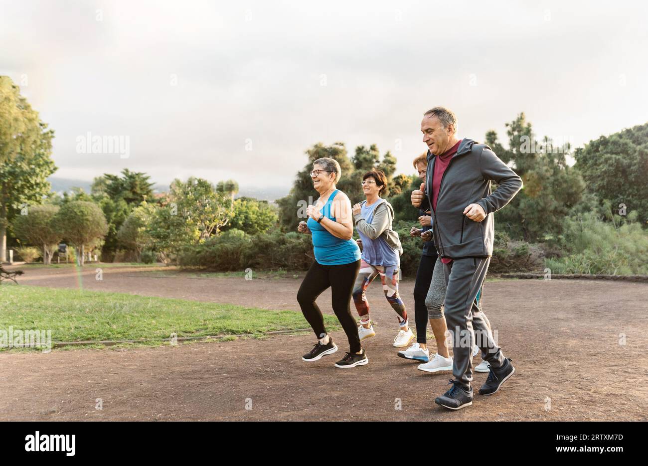 Group of diverse senior people jogging together at park Stock Photo