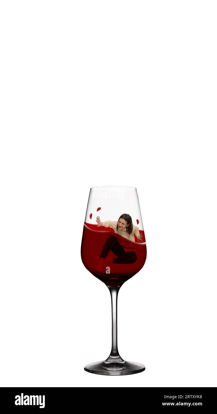 Young woman diving into glass with red wine. Female alcoholism, depression and problems