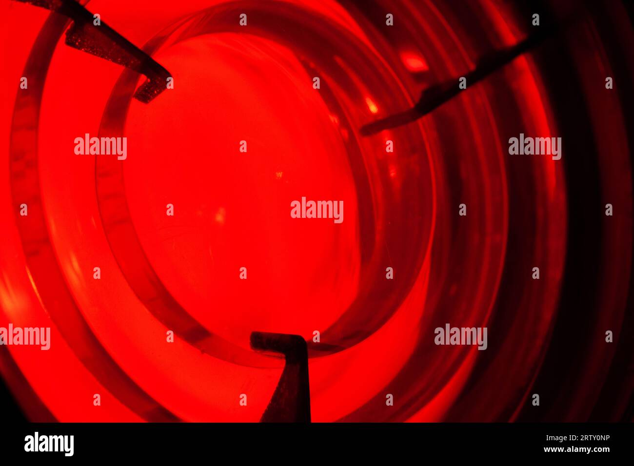 Red light is behind a Fresnel lens. It is a type of composite compact lens developed by the French physicist Augustin-Jean Fresnel for use in lighthou Stock Photo