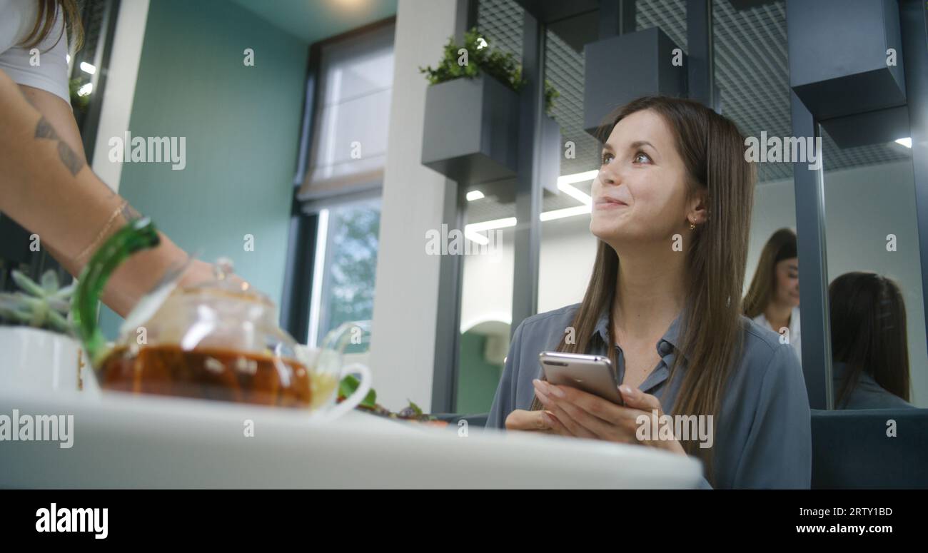Woman sits at the table in modern clinic cafe after appointment with