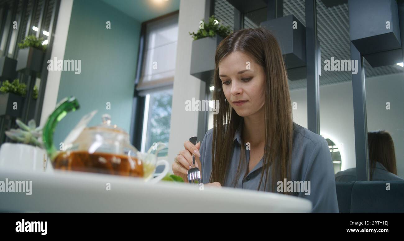 Woman sits at the table in modern clinic cafe after appointment with