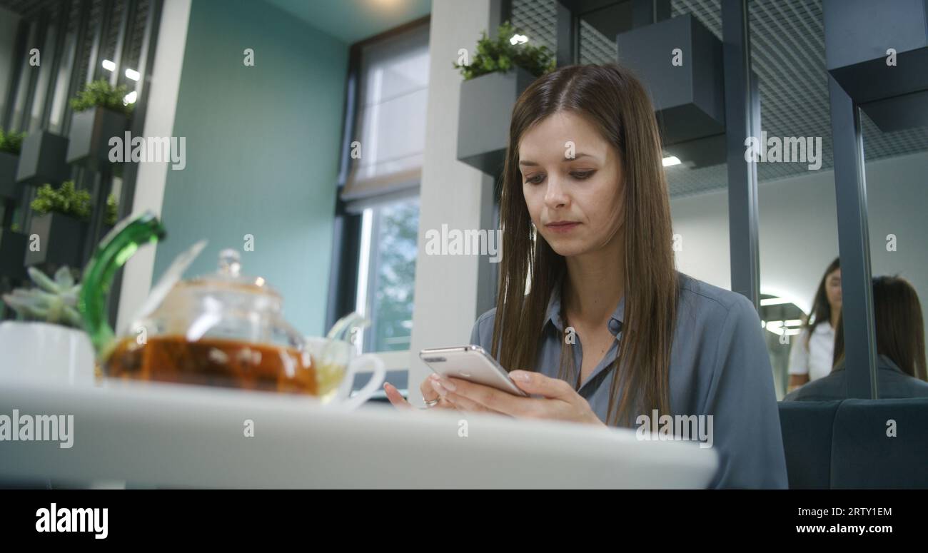 Woman sits at the table in modern clinic cafe after appointment with