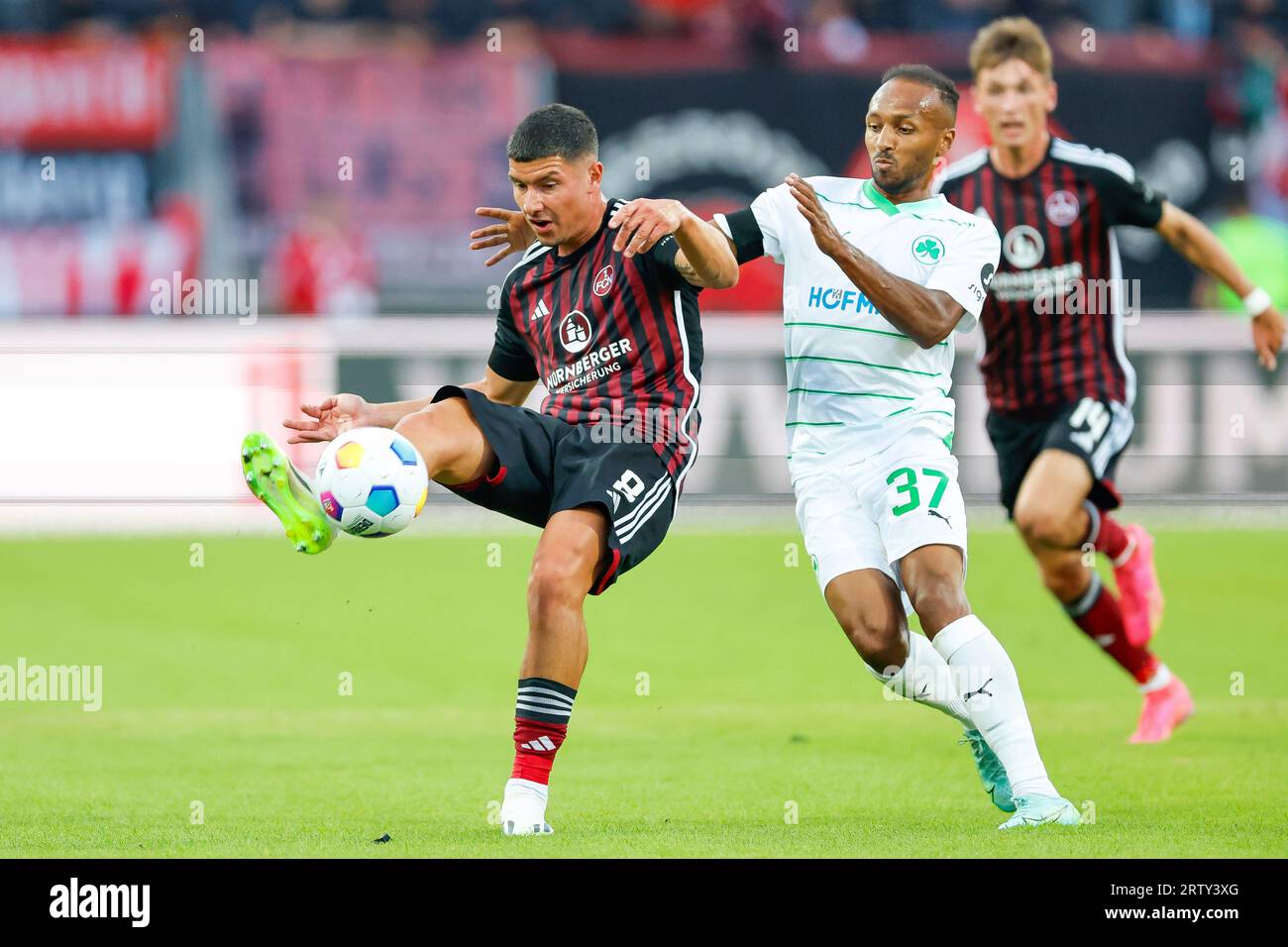 Nuremberg, Germany. 15th Sep, 2023. Soccer: 2nd Bundesliga, 1. FC Nürnberg - SpVgg Greuther Fürth, Matchday 6, Max Morlock Stadium. Nuremberg's Taylan Duman (l) and Fürth's Julian Green (M) fight for the ball. Credit: Daniel Löb/dpa - IMPORTANT NOTE: In accordance with the requirements of the DFL Deutsche Fußball Liga and the DFB Deutscher Fußball-Bund, it is prohibited to use or have used photographs taken in the stadium and/or of the match in the form of sequence pictures and/or video-like photo series./dpa/Alamy Live News Stock Photo