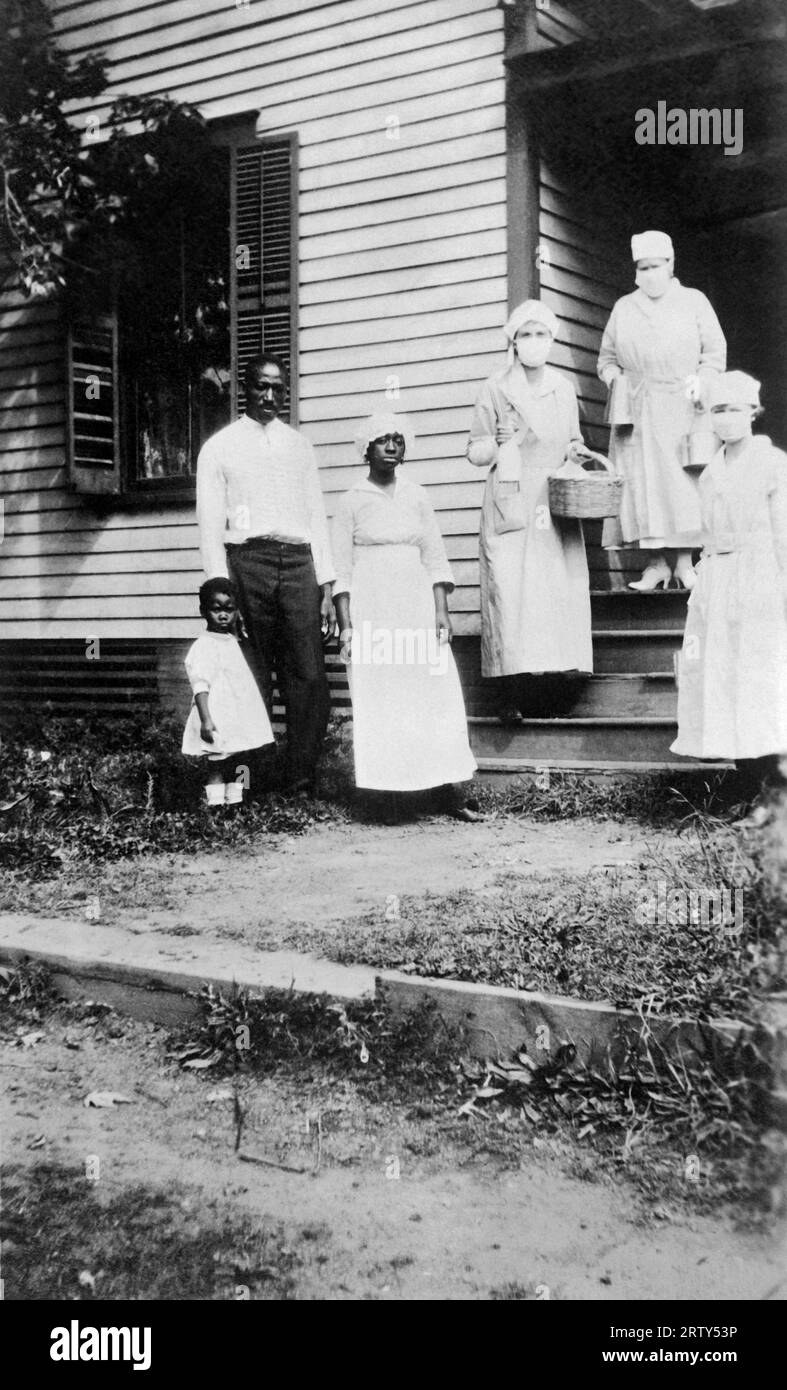 Charlotte, North Carolina    October 16, 1918 Red Cross canteen workers, Mrs. Ralph Van Landingham, Mrs. Cameron Morrison, and Miss Julia Baxter Scott, taking food to a colored family who are all down with the 'Flu.' They found the mother had just died. Stock Photo