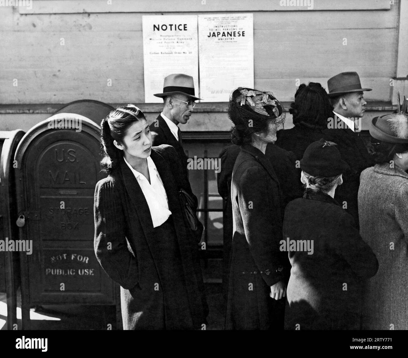 San Francisco, California       April 1942  Japanese-American Shizuko Ina standing behind others waiting to be assigned a 'family number' before being removed from their homes and incarcerated in a detention facility at Tanforan Racetrack. She was later moved with her husband, Itaru Ina to a concentration camp in Topaz, Utah, and then to Tule Lake Segregation Center, near Newell in Northern California. The family was separated in July 1945 when Itaru was transferred to Fort Lincoln, a Department of Justice camp for 'enemy aliens' in Bismarck, North Dakota, and reunited in April 1946 at Crystal Stock Photo