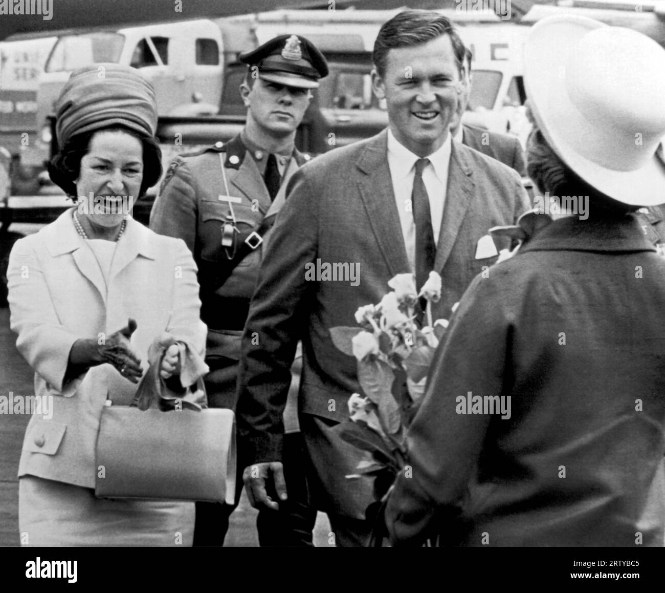 Boston, Massachusetts  June 9, 1964. Mrs. Lyndon B. Johnson greets Mrs. Endicott Peabody, wife of the governor of Massachusetts. The First Lady arrived in Boston today to speak at the Radcliffe Commencement, and is escorted by Governor Peabody. Stock Photo