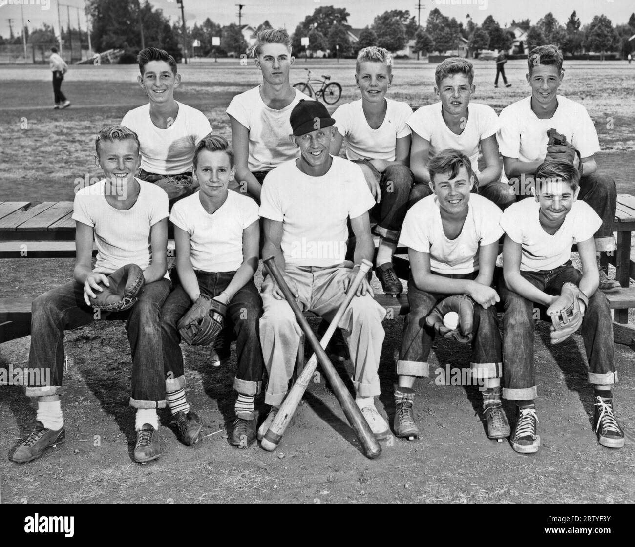 United States c. 1950. A little league team and their coach pose for