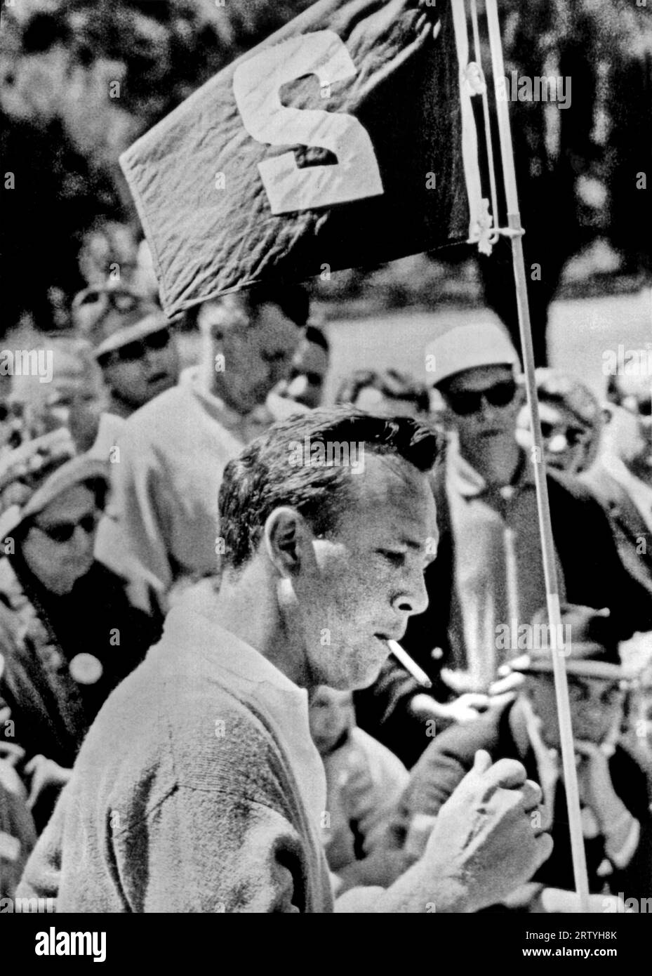 Augusta, Georgia  April 8, 1961 Defending Masters champion, Arnold Palmer, puffs on a cigarette as he stands besides the flag on the second green during the second round. Stock Photo
