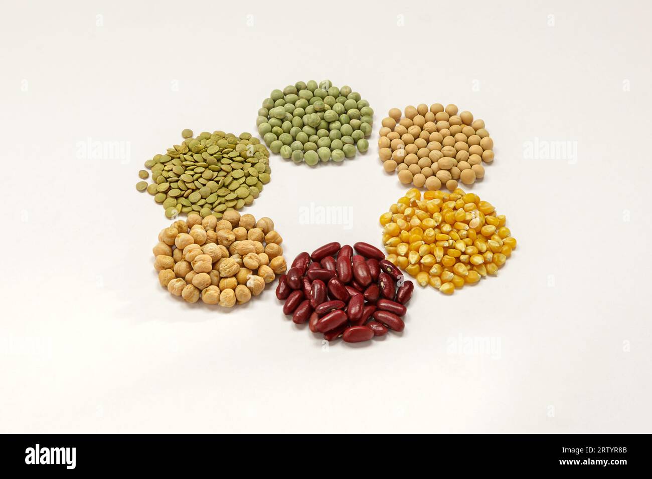 Granos secos típicos de América latina, lentejas, arvejas verdes, arvejas secas, maíz, frijol rojo, garbanzos sobre fondo blanco - Typical Latin meal Stock Photo
