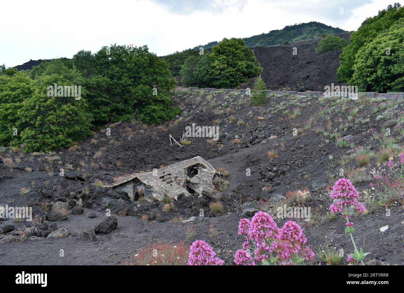 House covered with lava at the foot of Mount Etna volcano, surrounding