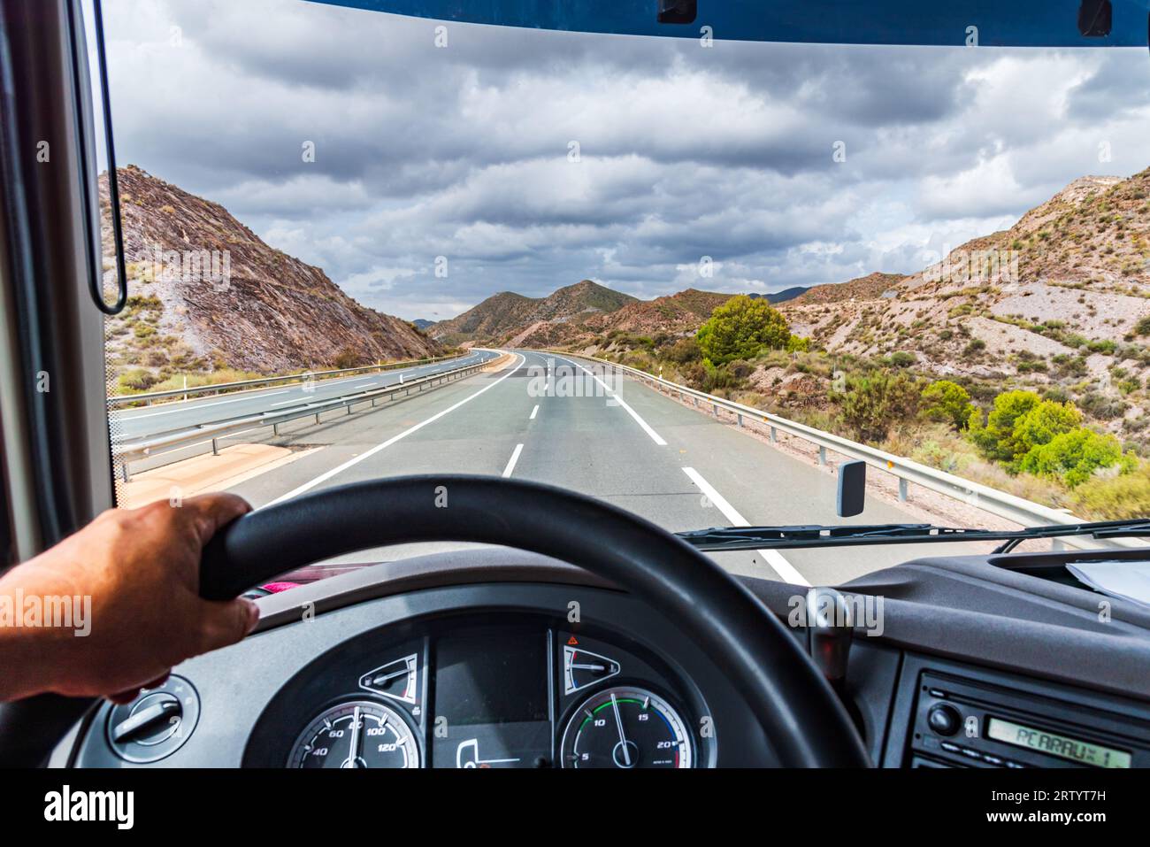 View from the driving position of a truck of the highway and a mountainous landscape. Stock Photo