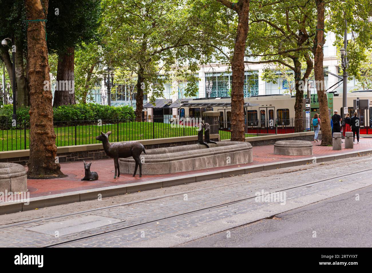 Doe and fawn and two otter sculptures near a fountain on the sidewalk in downtown Portland Oregon Stock Photo