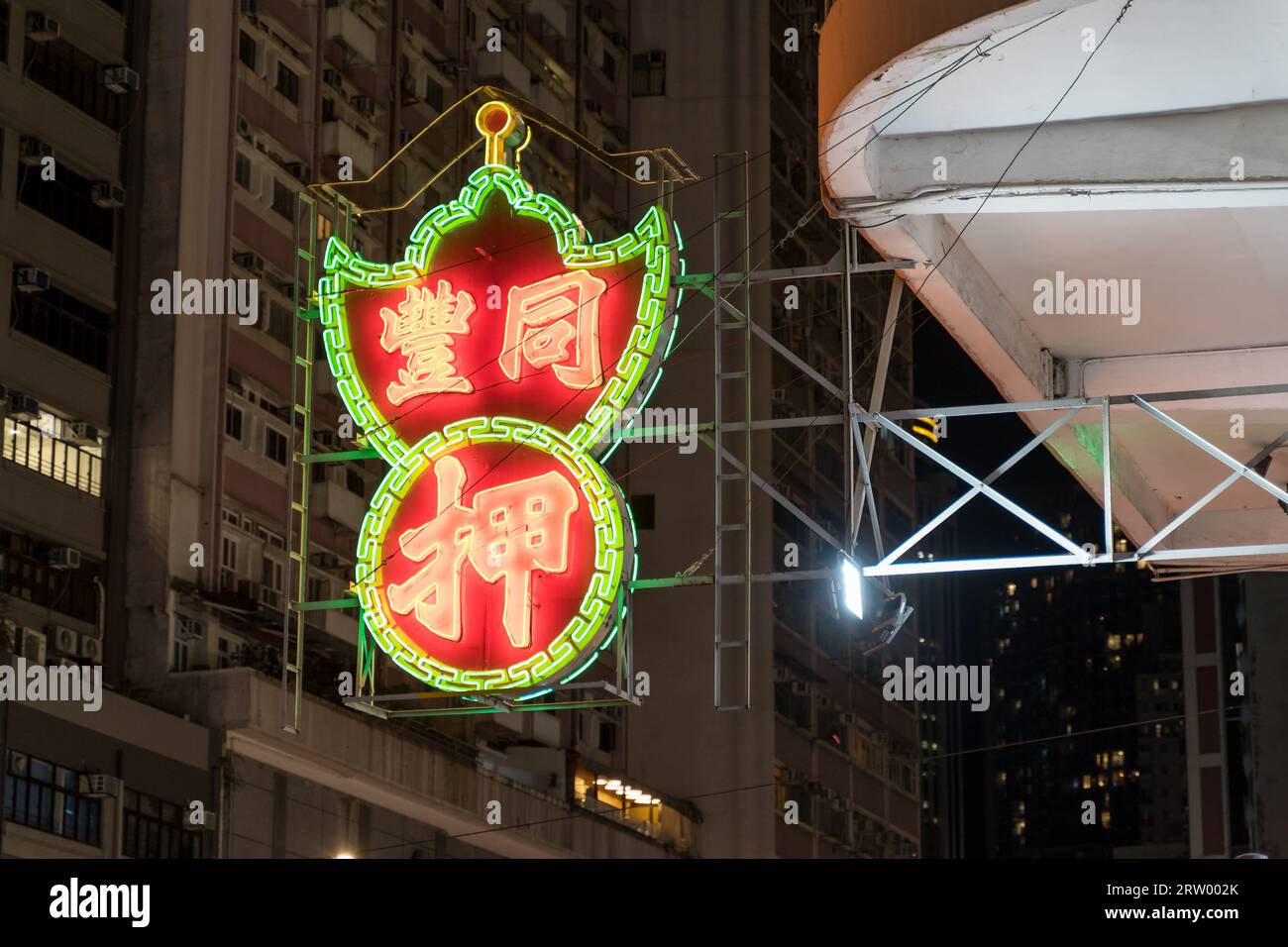 Pawn shop neon light advertising sign at night on the street corner of Wan Chai. Hong Kong - 28th August 2023 Stock Photo