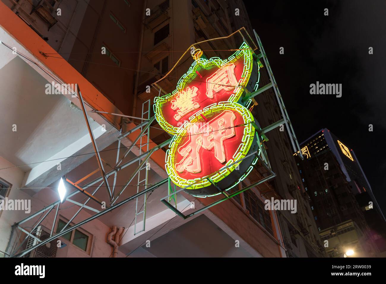 Pawn shop neon light advertising sign at night on the street corner of Wan Chai. Hong Kong - 28th August 2023 Stock Photo
