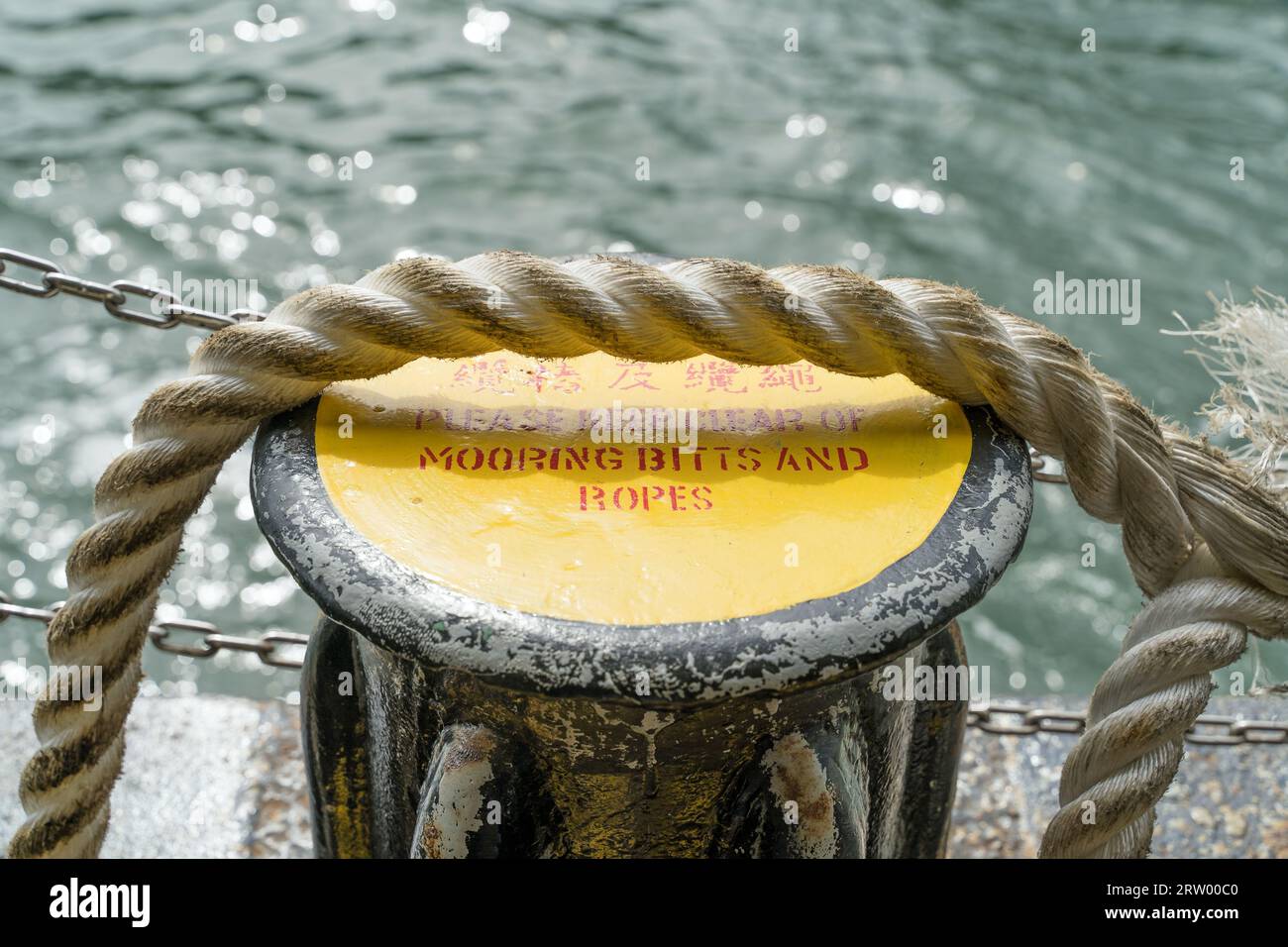 Mooring bitts and ropes and a warning sign on a ferry at sea on a sunny day Stock Photo