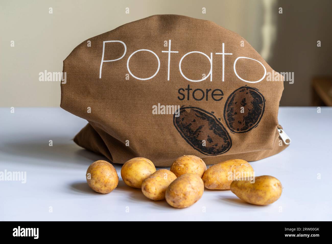 Potatoes and a brown cotton potato storage bag Stock Photo