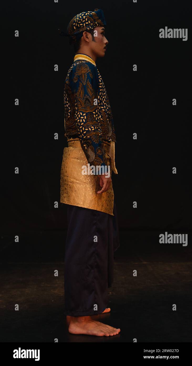 An Asian Man Wearing A Traditional Costume With Beautiful Motifs On His an-asian-man-wearing-a-traditional-costume-with-beautiful-motifs-on-his