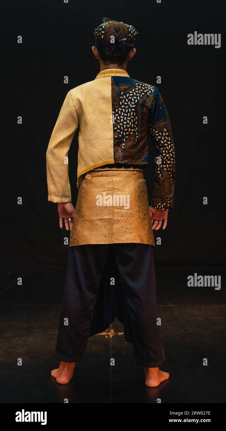 an Asian man wearing a traditional costume with beautiful motifs on his  shirt and wearing a bandana called a bendo in a room with a black  background Stock Photo - Alamy