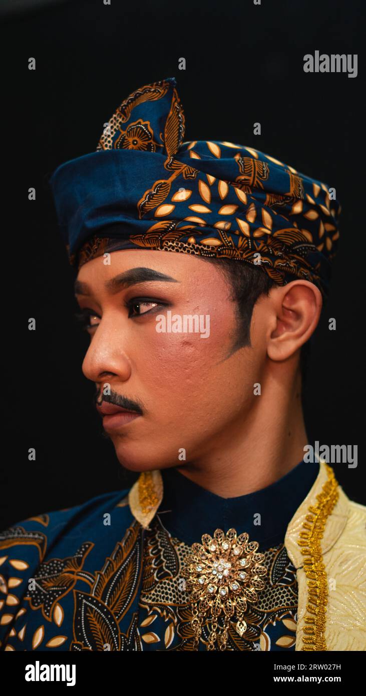 An Asian Man Wearing A Traditional Costume With Beautiful Motifs On His an-asian-man-wearing-a-traditional-costume-with-beautiful-motifs-on-his