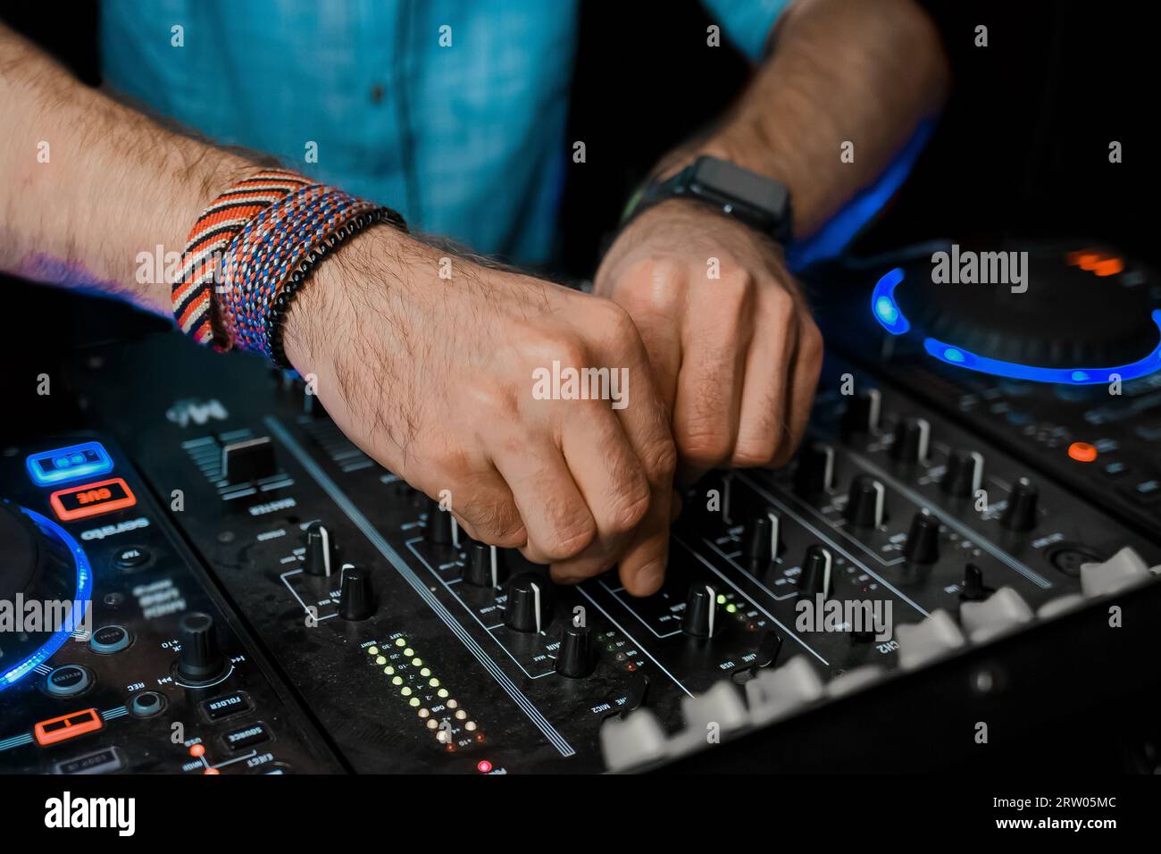 DJ hands playing on professional club equipment controller, close-up, nightlife example. Stock Photo
