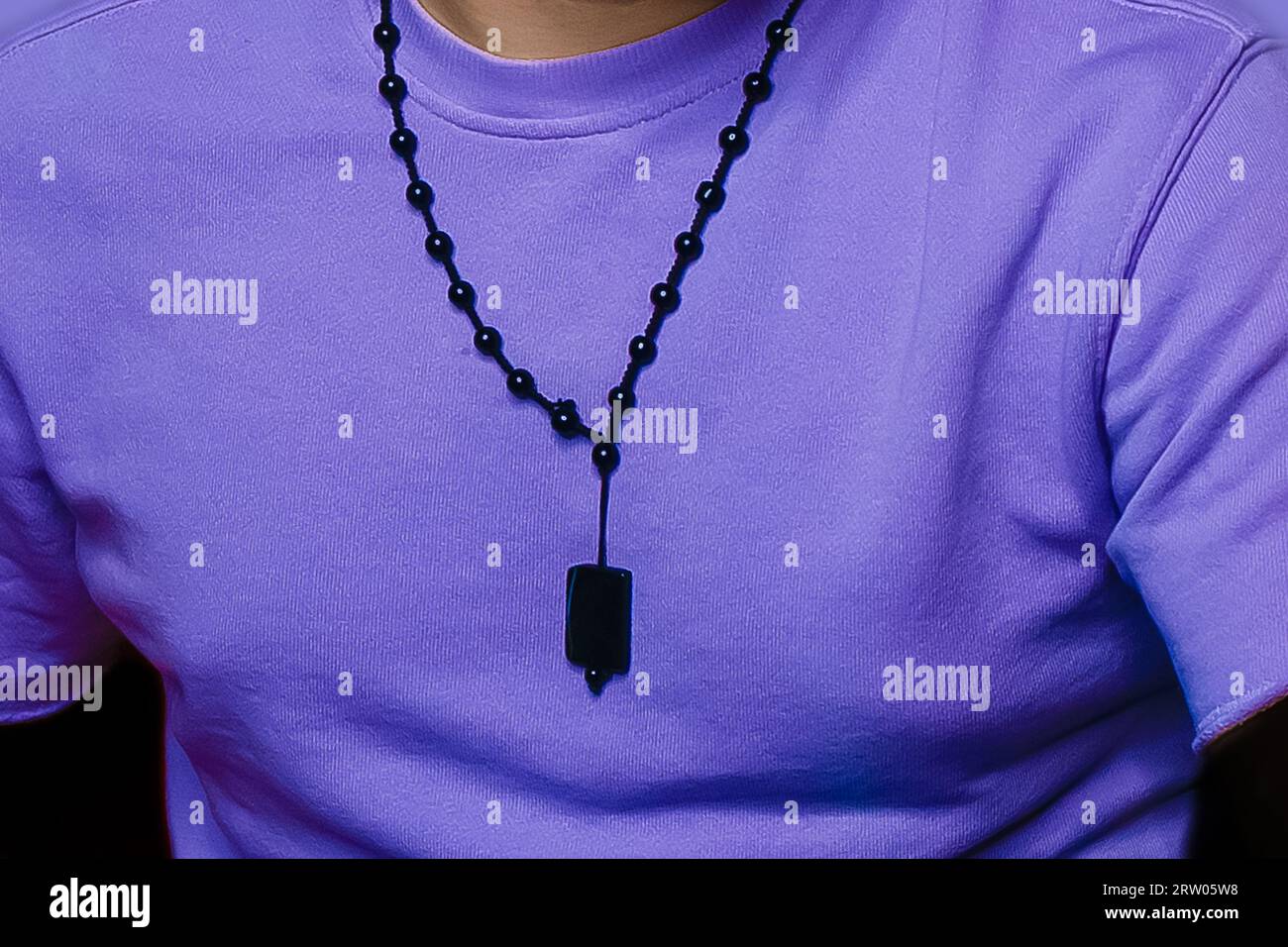 Men's style clothing fashionable lilac T-shirt with a decoration around the neck close-up. Stock Photo