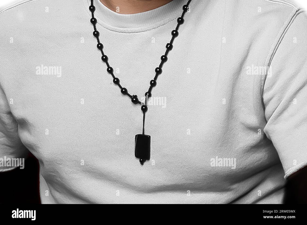Men's style clothing fashionable white T-shirt with a decoration around the neck close-up. Stock Photo