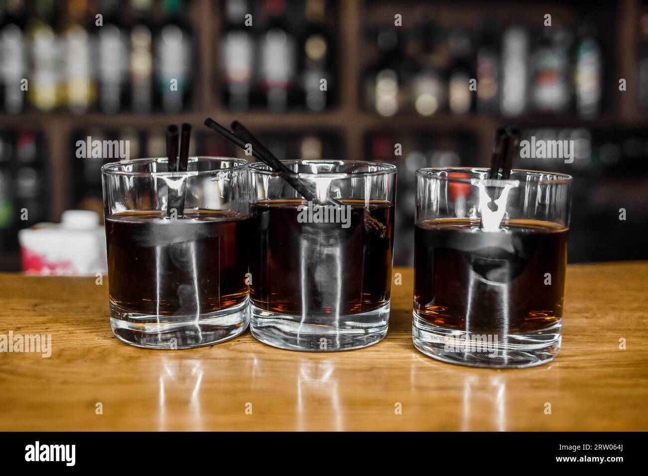 3 cocktails alcohol whiskey with Coca Cola stand on the bar in a nightclub close-up. Stock Photo