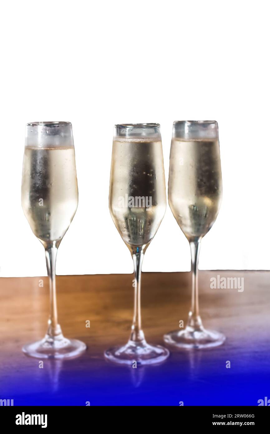 Chilled light alcohol in 3 glasses of champagne on the bar on a white